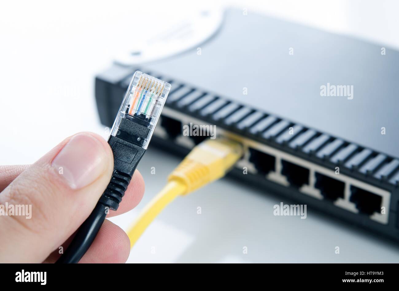 Commutatore di rete del dispositivo e i cavi ethernet su sfondo bianco Foto Stock