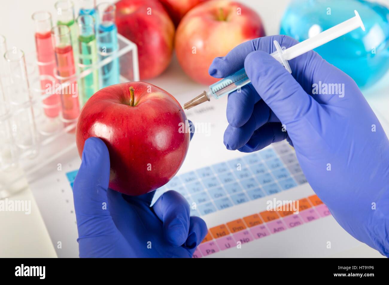 Analista viene iniettato il liquido in apple. Alimenti geneticamente modificati in lab concept. Foto Stock