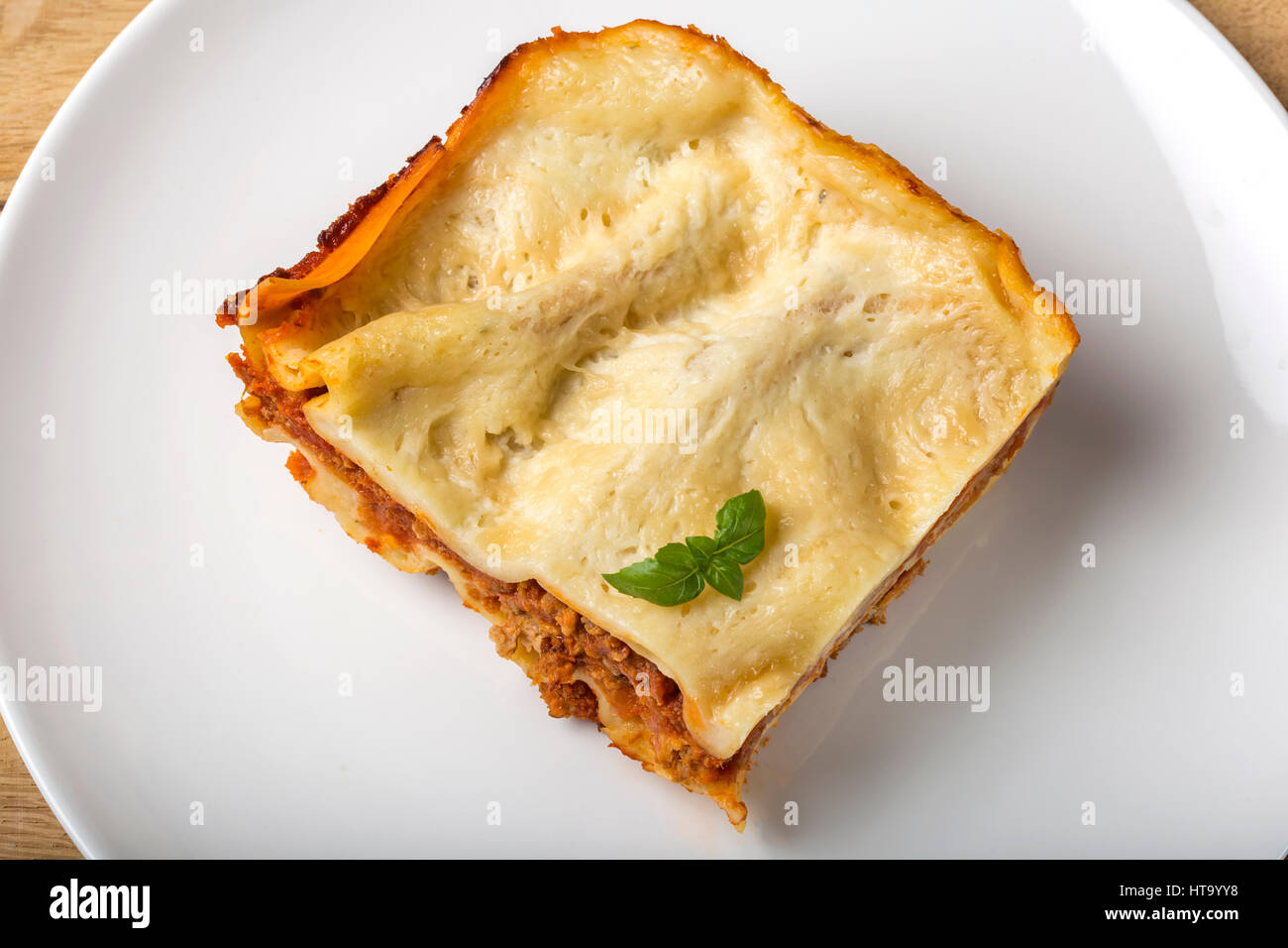 Casalingo italiano lasagne bolognesi sulla piastra bianca con basilico Foto Stock