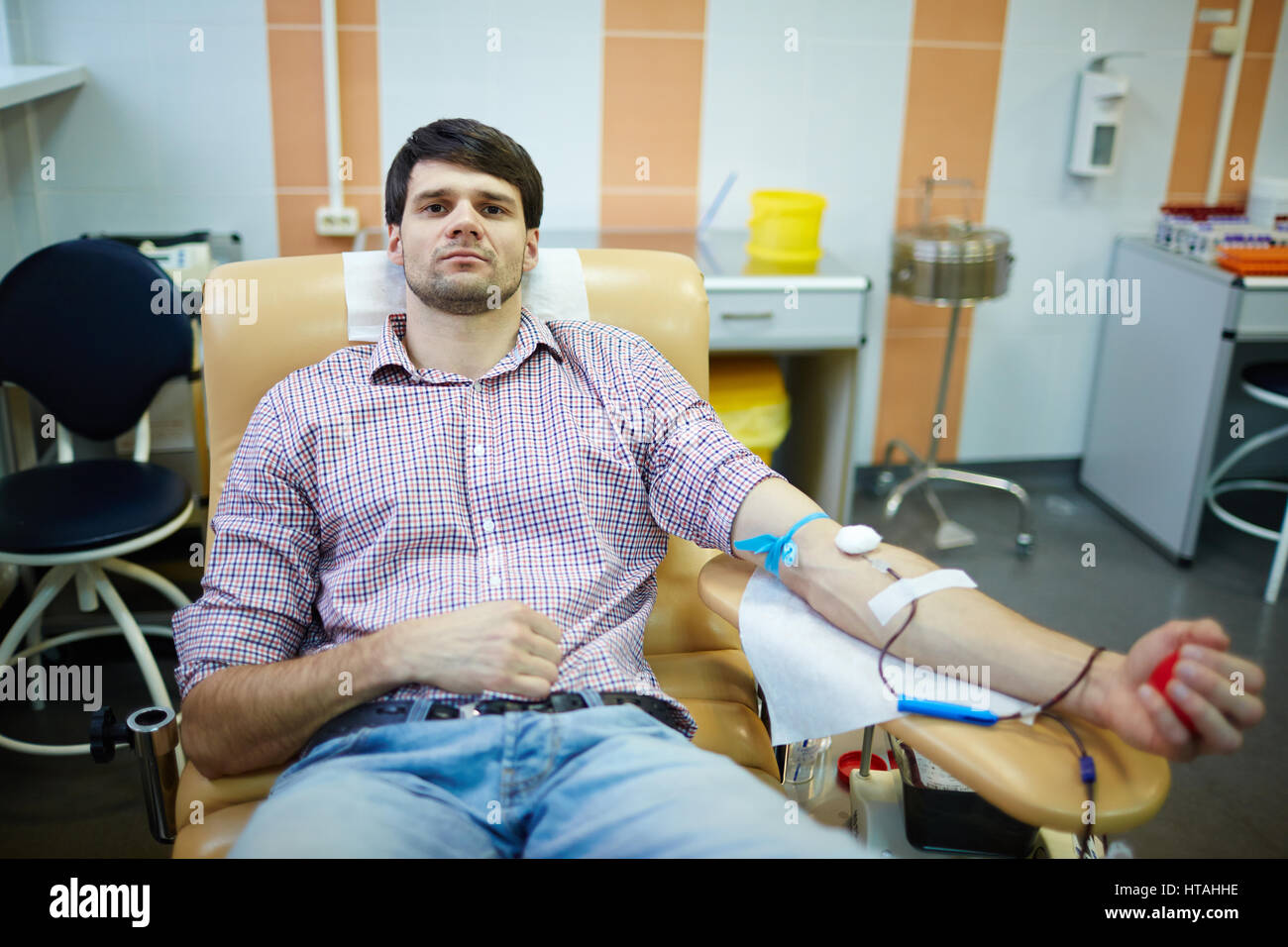Uomo con contagocce donare il proprio sangue in ospedale Foto Stock