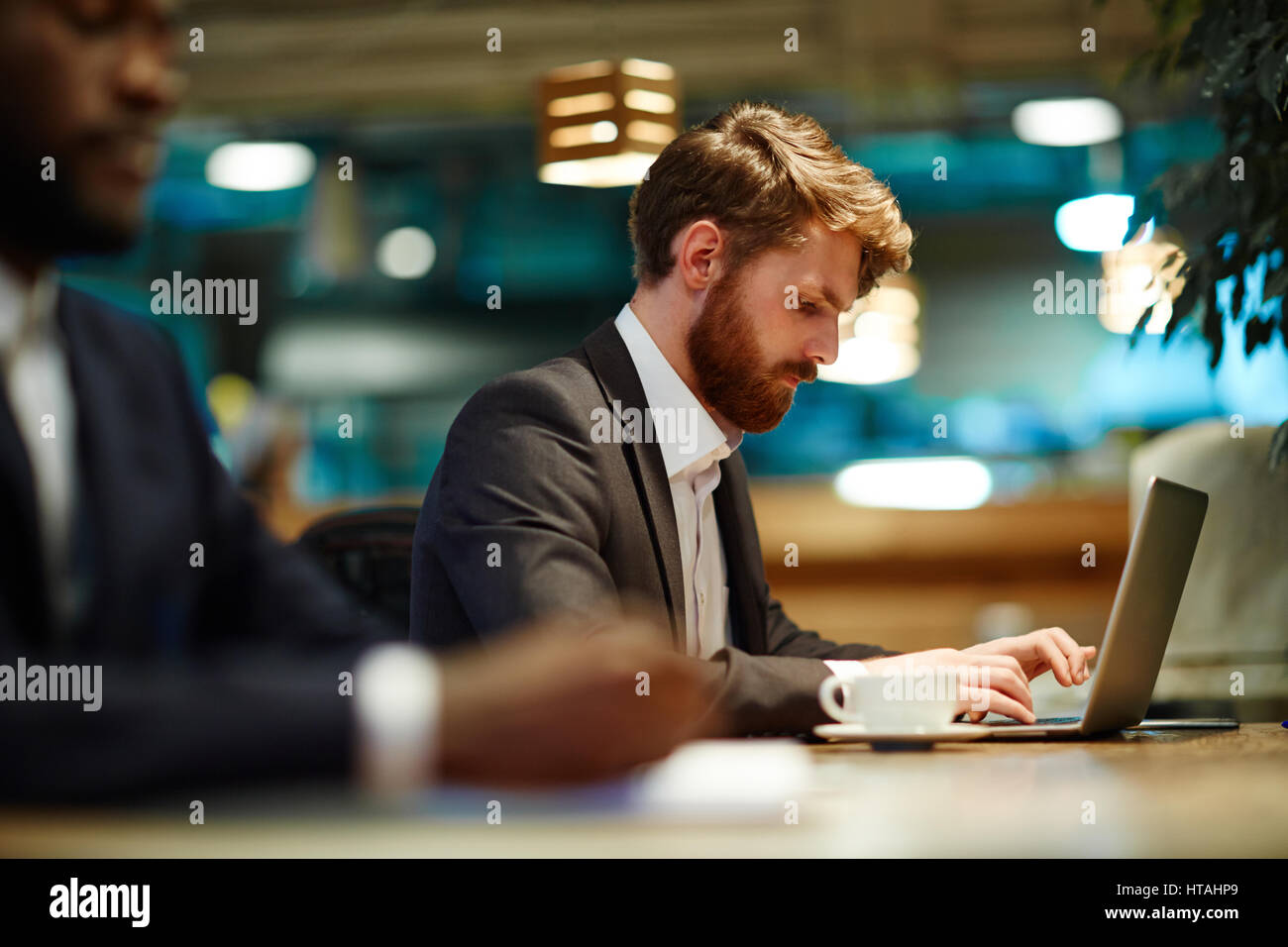 Grave giovane economista immettendo i dati importanti Foto Stock