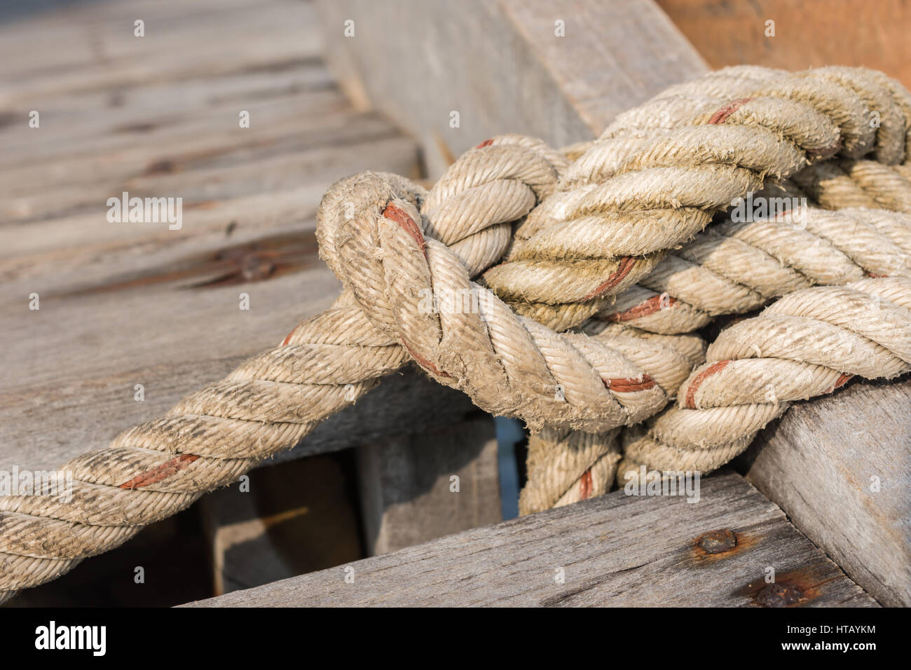 Corda allacciate fino a un nodo su un ponte di legno Foto Stock