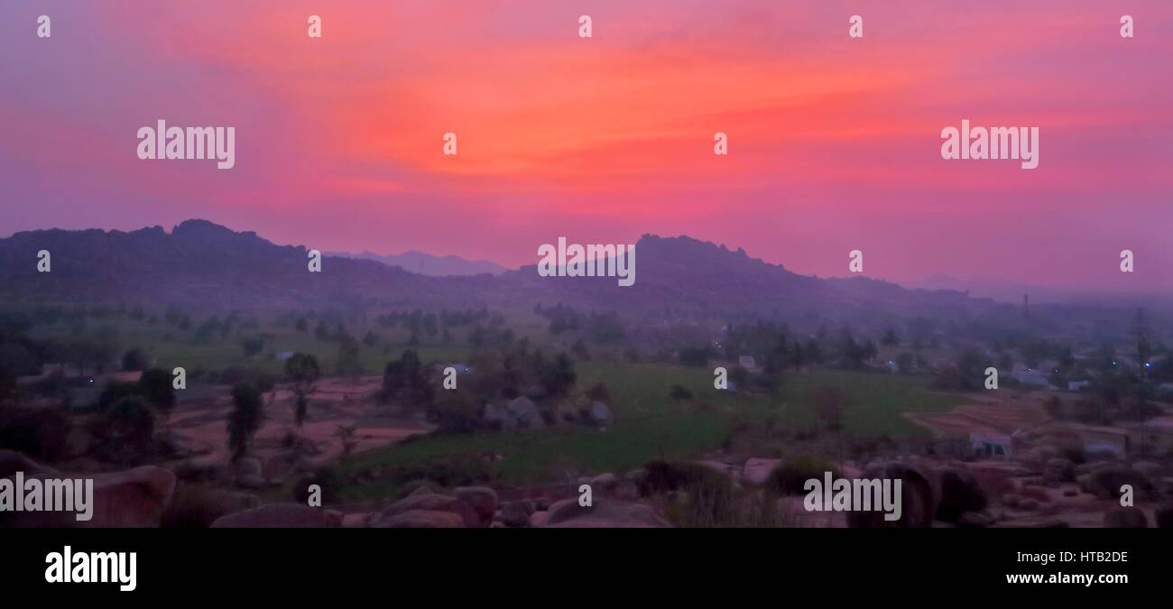 Momenti prima dell'alba da una montagna in Sanapur, nei pressi di Hampi, affacciato sul riso plantages e le montagne in distanza. Foto Stock