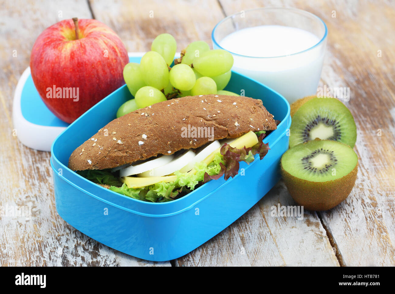 Sana opzione Pranzo consistente di marrone formaggio e uova sandwich, frutta fresca e bicchiere di latte Foto Stock