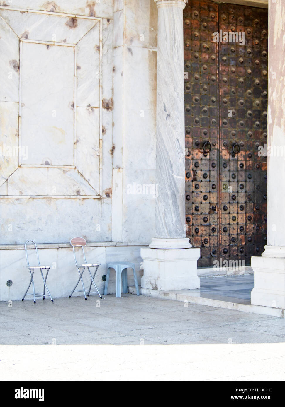 Sedie di attendere al di fuori di una grande porta di rame all'iconica Cupola della Roccia moschea a Gerusalemme, Israele. Foto Stock