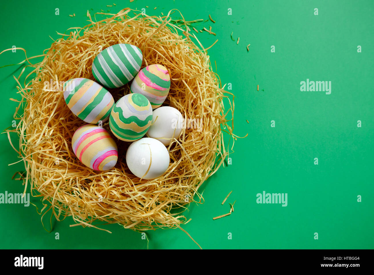 Vintage colorate uova di pasqua nel nido su sfondo verde. Foto Stock