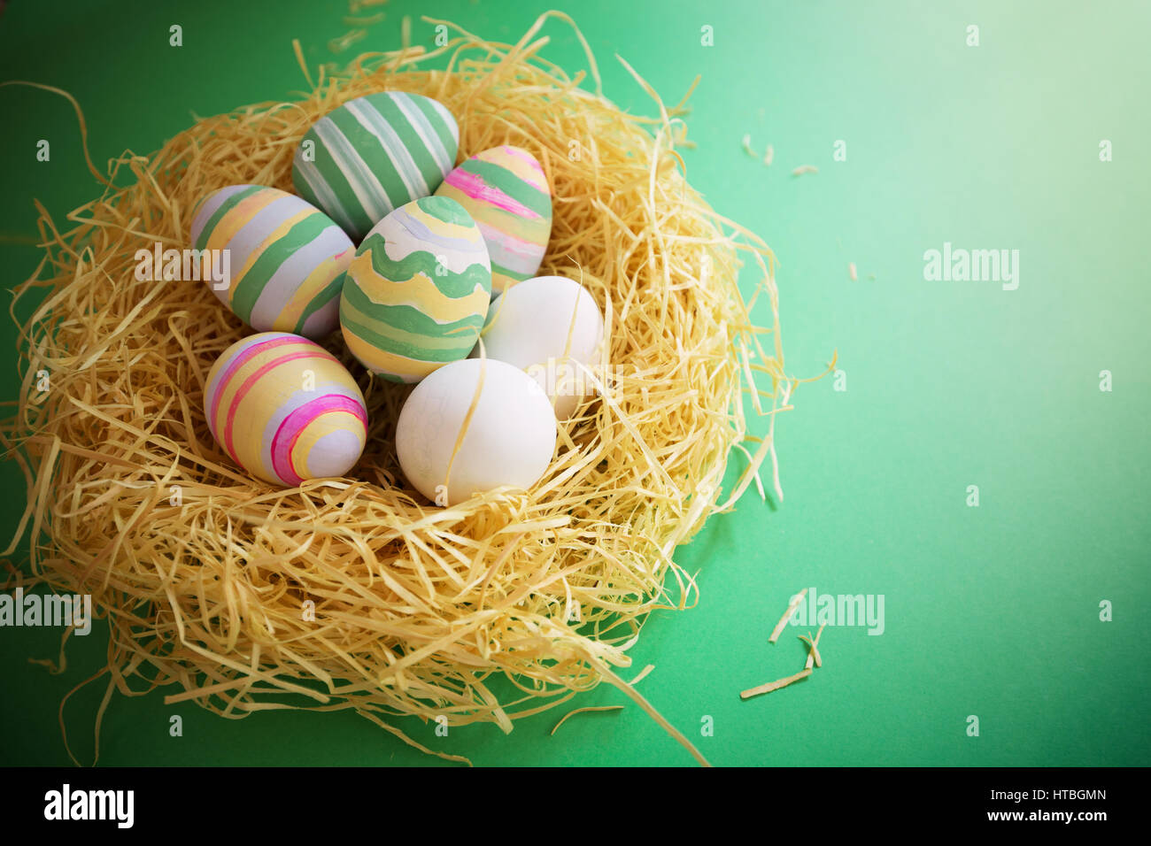 Vintage colorate uova di pasqua nel nido su sfondo verde. Foto Stock