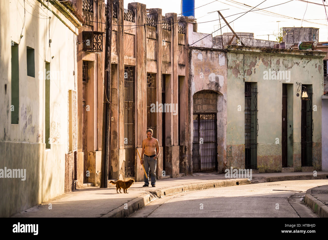 L'uomo con il cane a camminare in una strada a Camaguey del centro storico Foto Stock