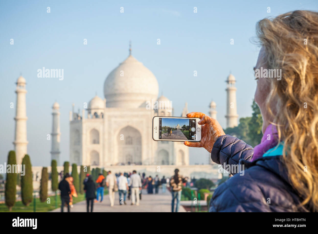 Una donna takinga foto del Taj Mahal di Agra, in India con il suo iPhone 6. Foto Stock