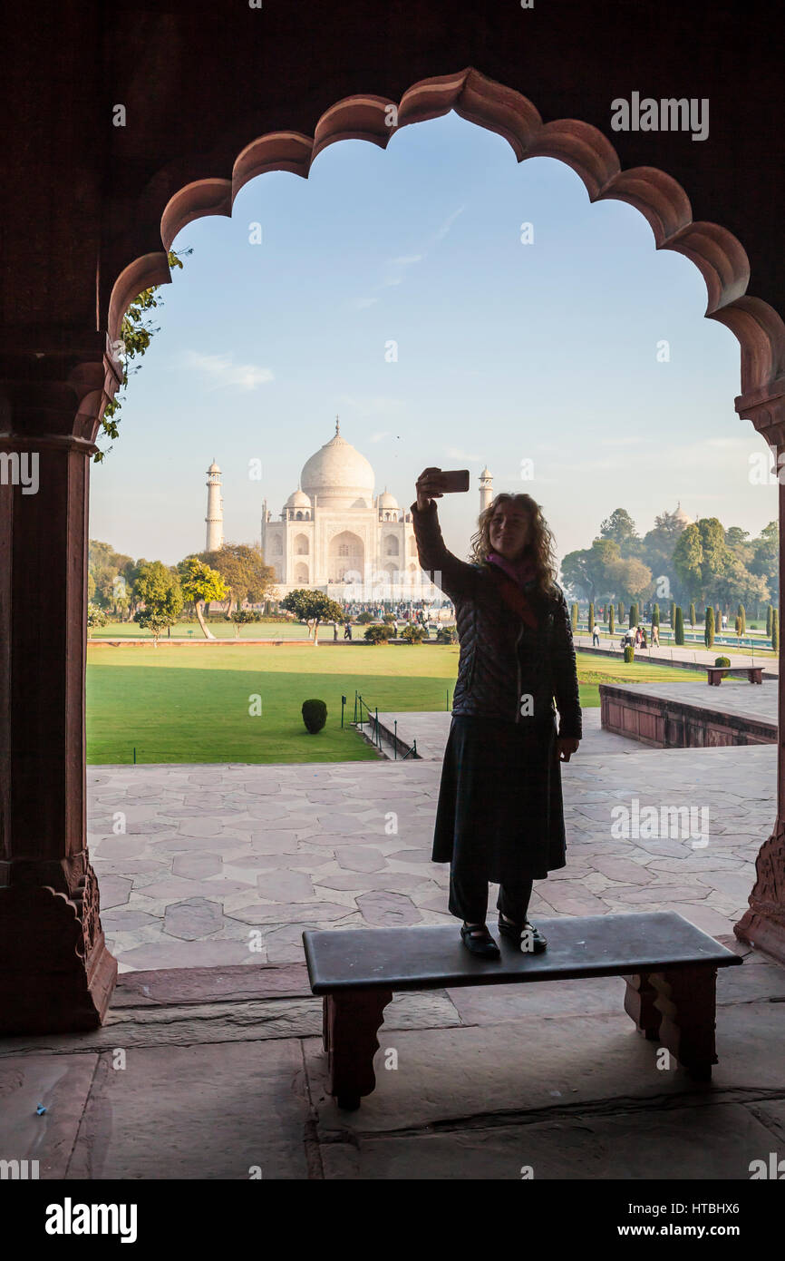 Una donna che fa un ritratto selfie al Taj Mahal di Agra, India. Foto Stock