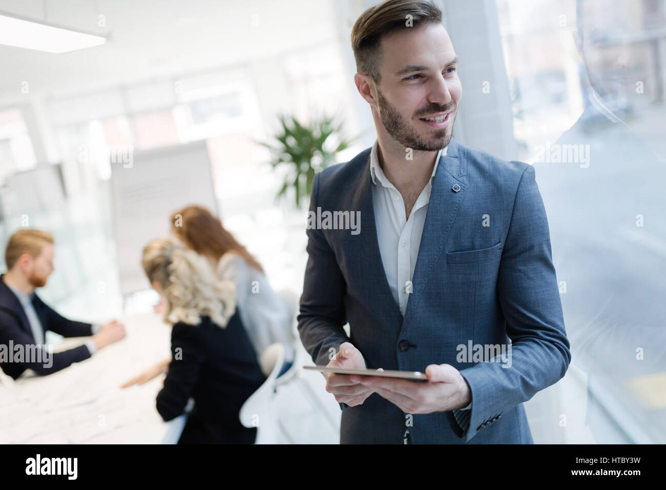 Imprenditore e lavoro tenendo compressa in un ufficio moderno Foto Stock