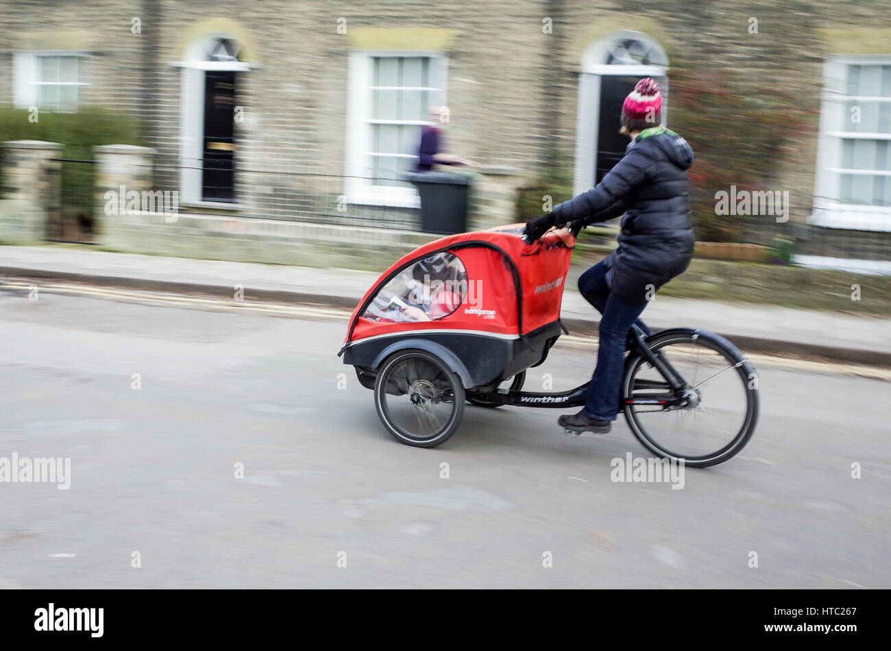 I genitori trasportano i loro bambini a scuola in bici da carico nel centro di Cambridge Foto Stock
