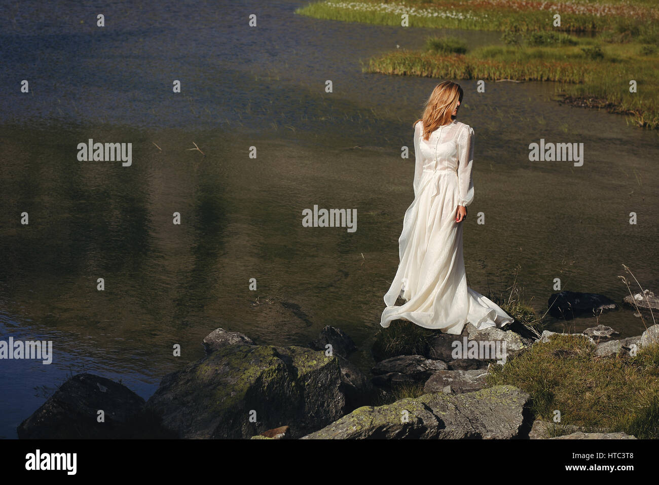Triste sposa in posa di un lago di montagna. Romantico e sognante Foto Stock