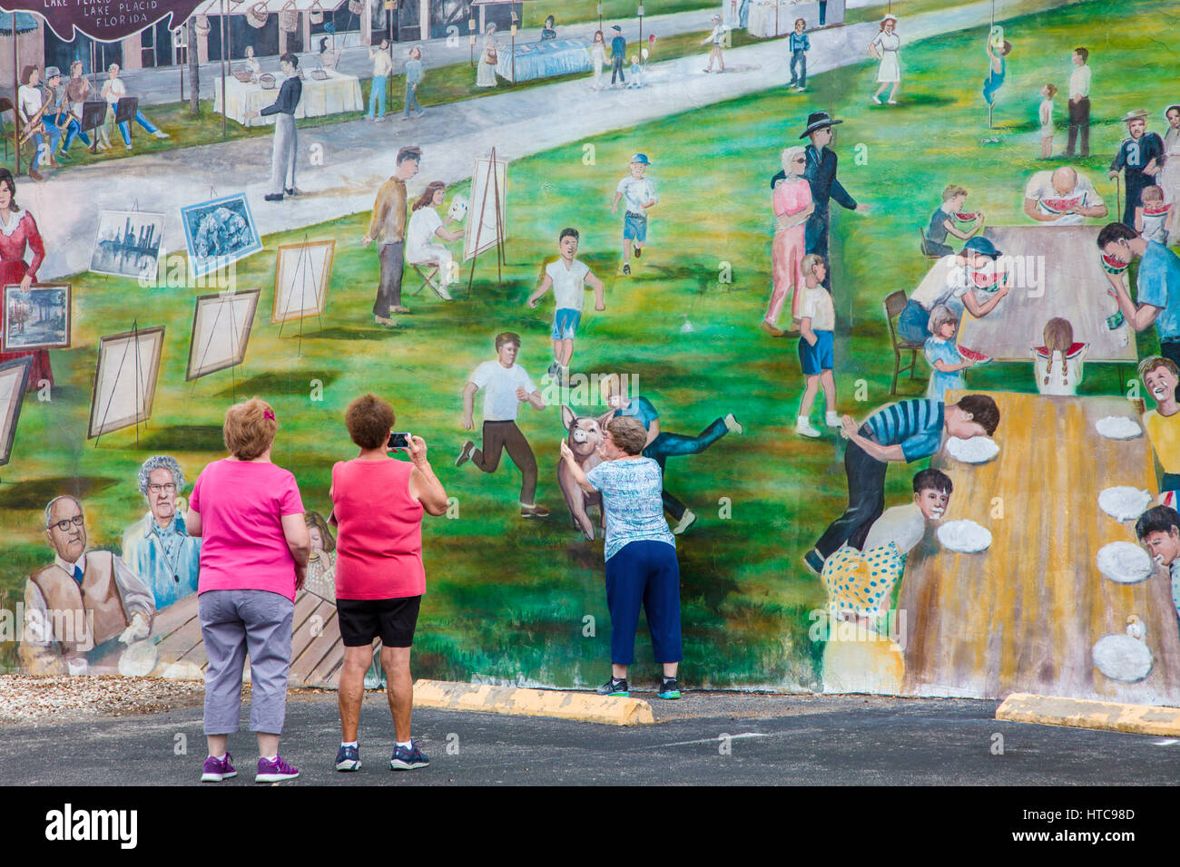 Le persone in cerca di art murales dipinti su edificio esterno pareti in Lake Placid Florida conosciuta come la città dei murales Foto Stock