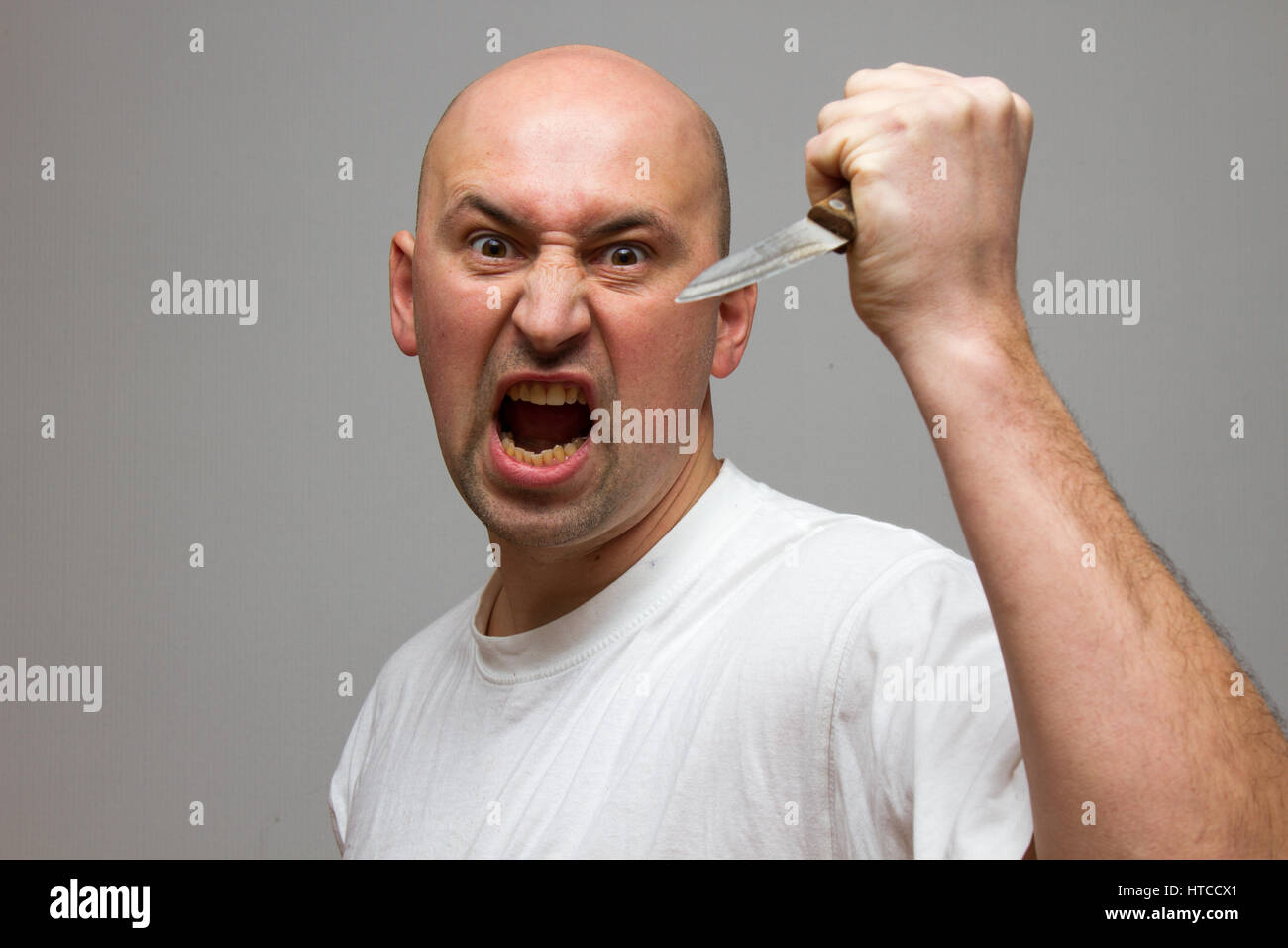 Enraged uomo con un coltello in una furia omicida Foto Stock