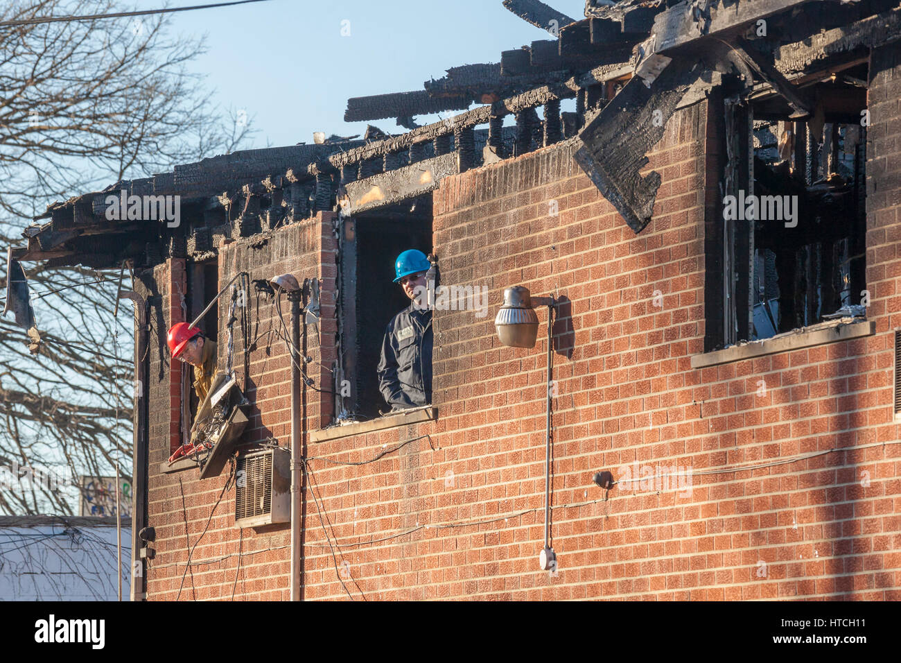 Detroit, Michigan - Cooperazione di polizia e vigili del fuoco incendio doloso investigatori sulla scena di un appartamento di fuoco che ha ucciso cinque persone. Il deliberatamente-set abete Foto Stock