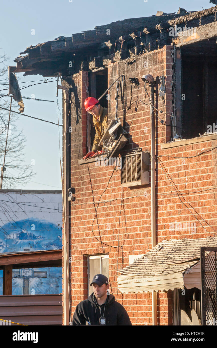 Detroit, Michigan - Cooperazione di polizia e vigili del fuoco incendio doloso investigatori sulla scena di un appartamento di fuoco che ha ucciso cinque persone. Il deliberatamente-set abete Foto Stock