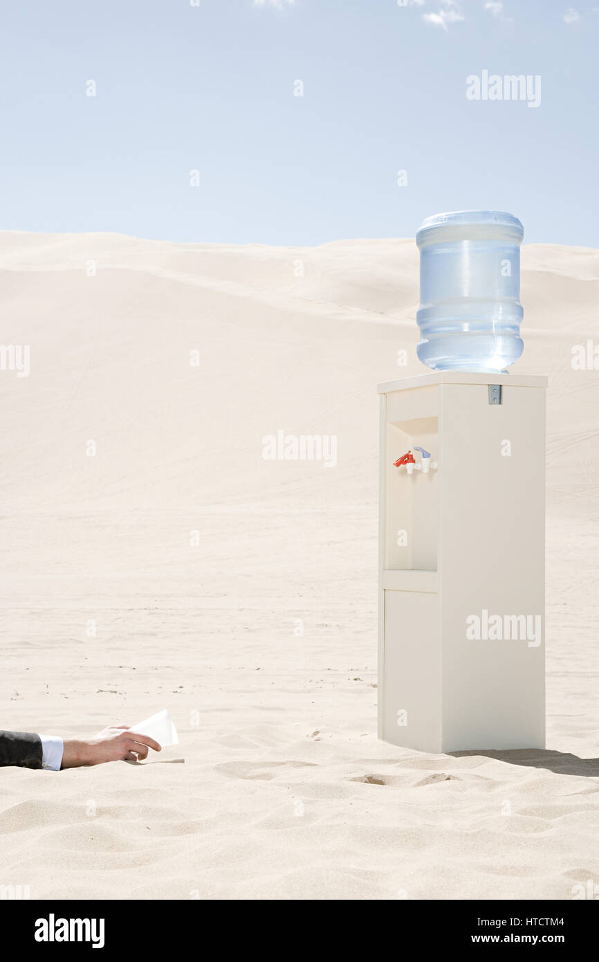 Persona di raggiungere per lo scambiatore di calore di acqua nel deserto Foto Stock