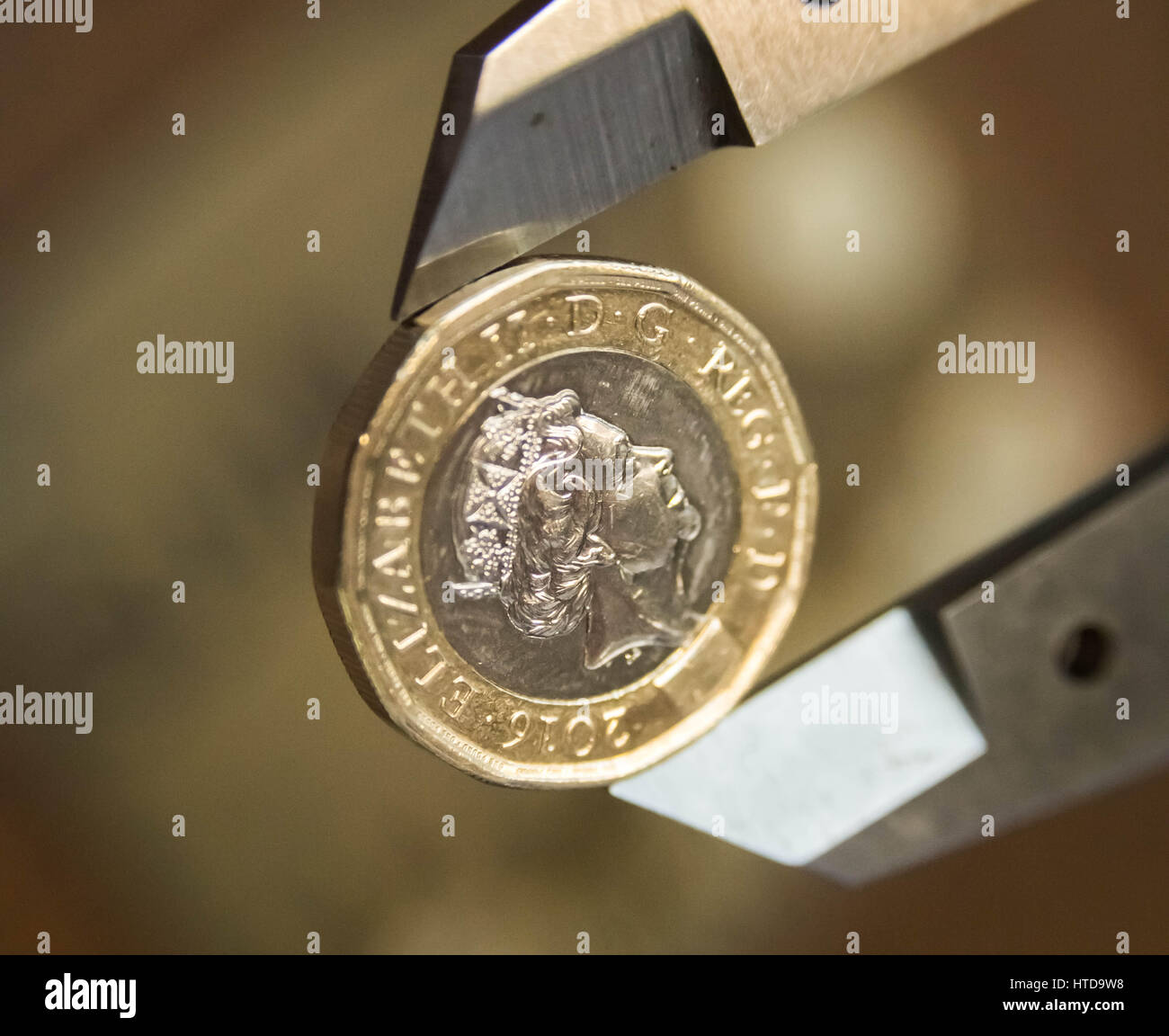 Londra, Regno Unito. 9 Mar, 2017. Nuovo £ 1 monete testato nel saggio di Londra ufficio prima del loro rilascio 28 marzo, 2017. Nella foto: uno dei nuovi 12 lati pound monete essendo misurato mediante un micrometro. Questa misura il diametro. Esso deve essere di 23mm o entro una certa tolleranza di che. Credito: Guy Corbishley/Alamy Live News Foto Stock