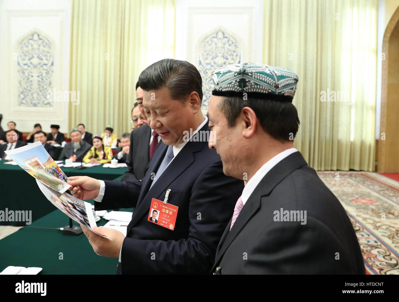 Pechino, Cina. Decimo Mar, 2017. Il presidente cinese Xi Jinping guarda le foto della famiglia di Kurban Tulum quando si unisce un panel di discussione con i deputati per il XII congresso nazionale del popolo (ANP) dal Xinjiang Uygur Regione Autonoma presso la sessione annuale della NPC a Pechino, capitale della Cina, 10 marzo 2017. Xi ha scritto per una figlia di Kurban Tulum, che per due volte è stato ricevuto dal compianto Presidente Mao Zedong, sottolineando la solidarietà etnica e gli sforzi per costruire un futuro luminoso per Xinjiang sotto la leadership del Partito Comunista della Cina (CPC). Credito: Xinhua/Alamy Live News Foto Stock