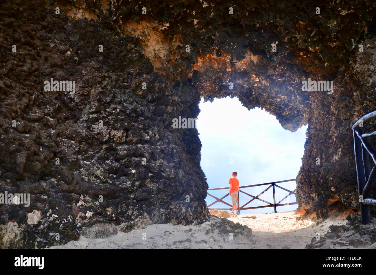 Un ragazzo fotografata attraverso un foro nella scogliera a strapiombo della Alba Acantilado del Amanecer isla mujeres messico Foto Stock