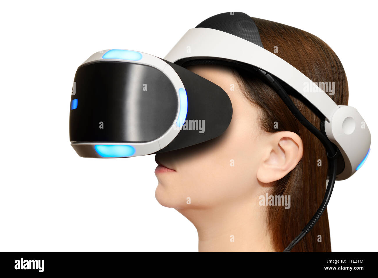 Donna che indossa una Playstation Sony Cuffie VR contro uno sfondo bianco. Foto Stock