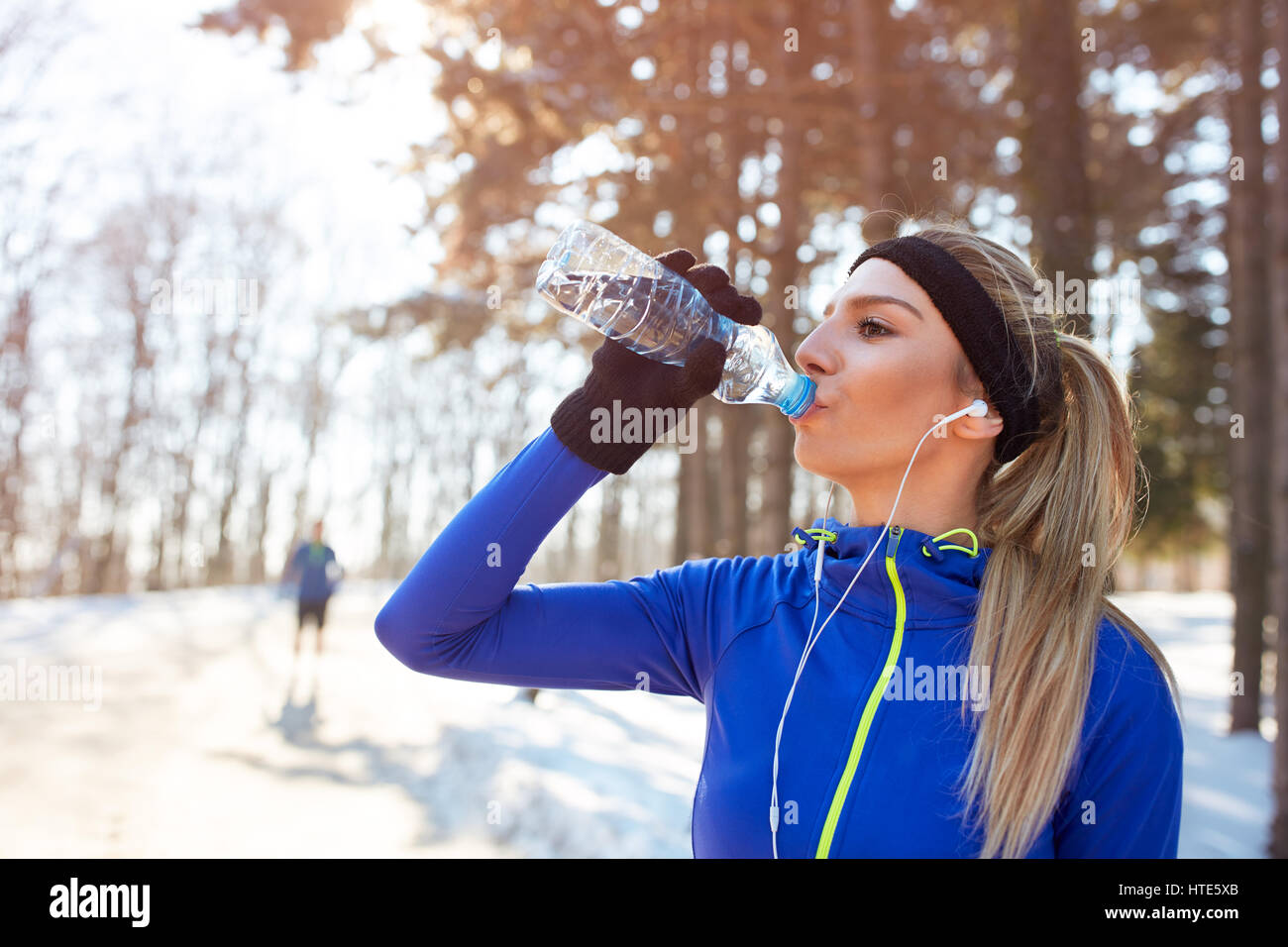 Ragazza beve l'acqua sull'allenamento invernale per esterno Foto Stock