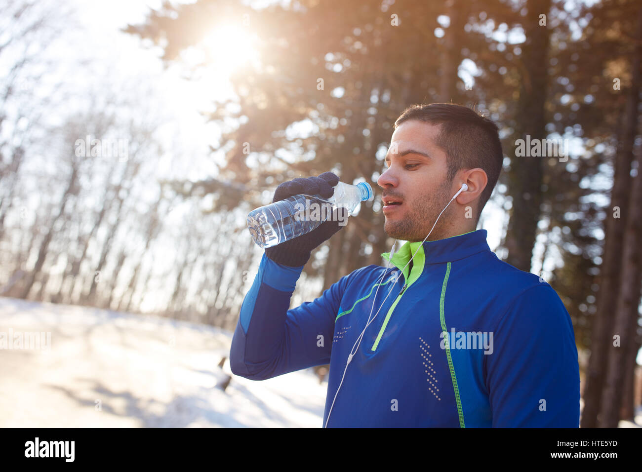 Runner maschio sulla rottura di formazione con una bottiglia di acqua minerale per esterno Foto Stock