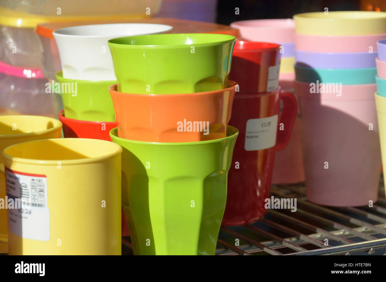 Colorate tazze di plastica in un negozio la finestra di visualizzazione. Foto Stock