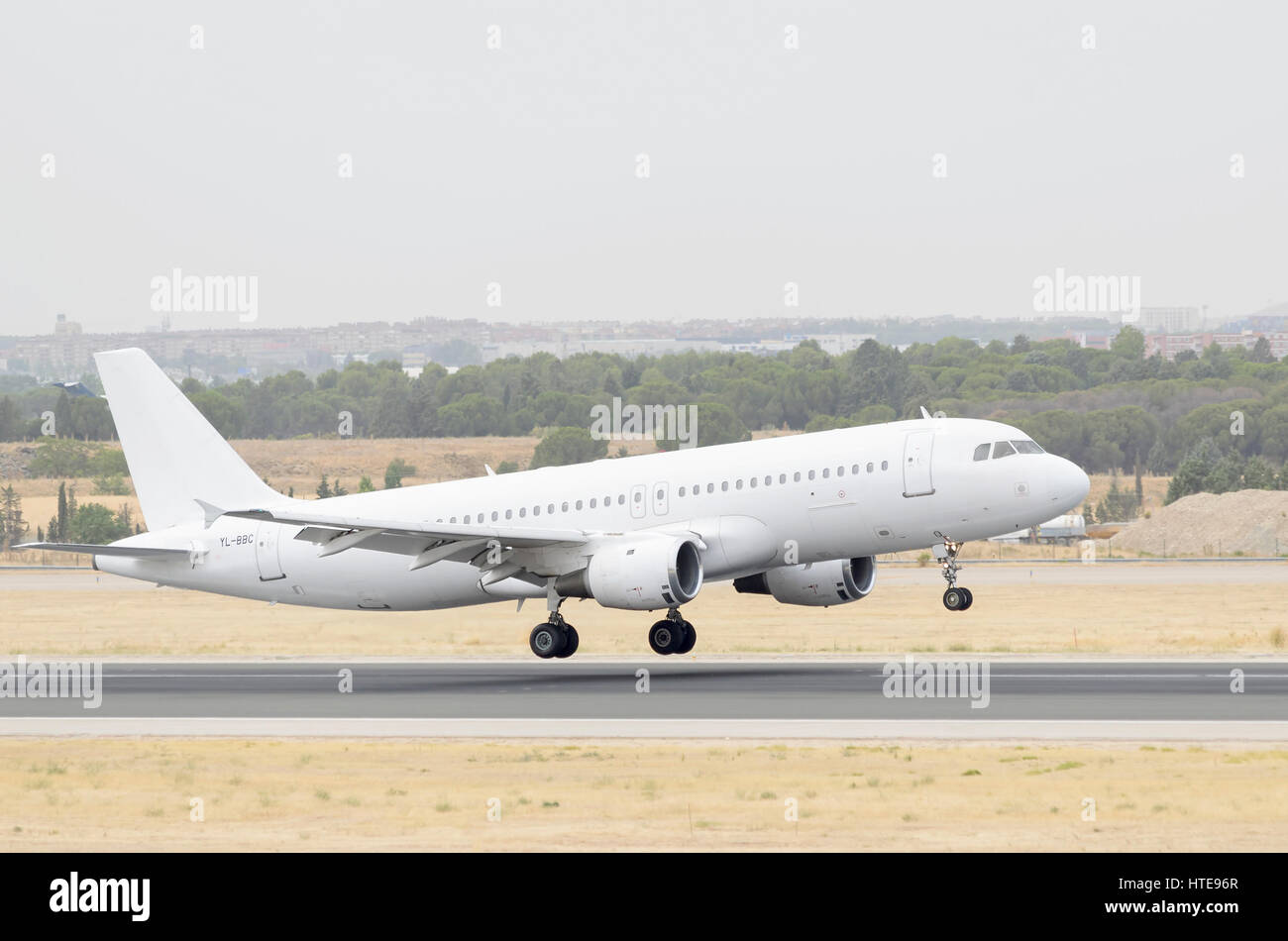 Completamente piano bianco Airbus A320, della compagnia aerea SmartLynx, è lo sbarco su Madrid - Barajas, Adolfo SUAREZ aeroporto. Nuvoloso Giorno di estate Foto Stock