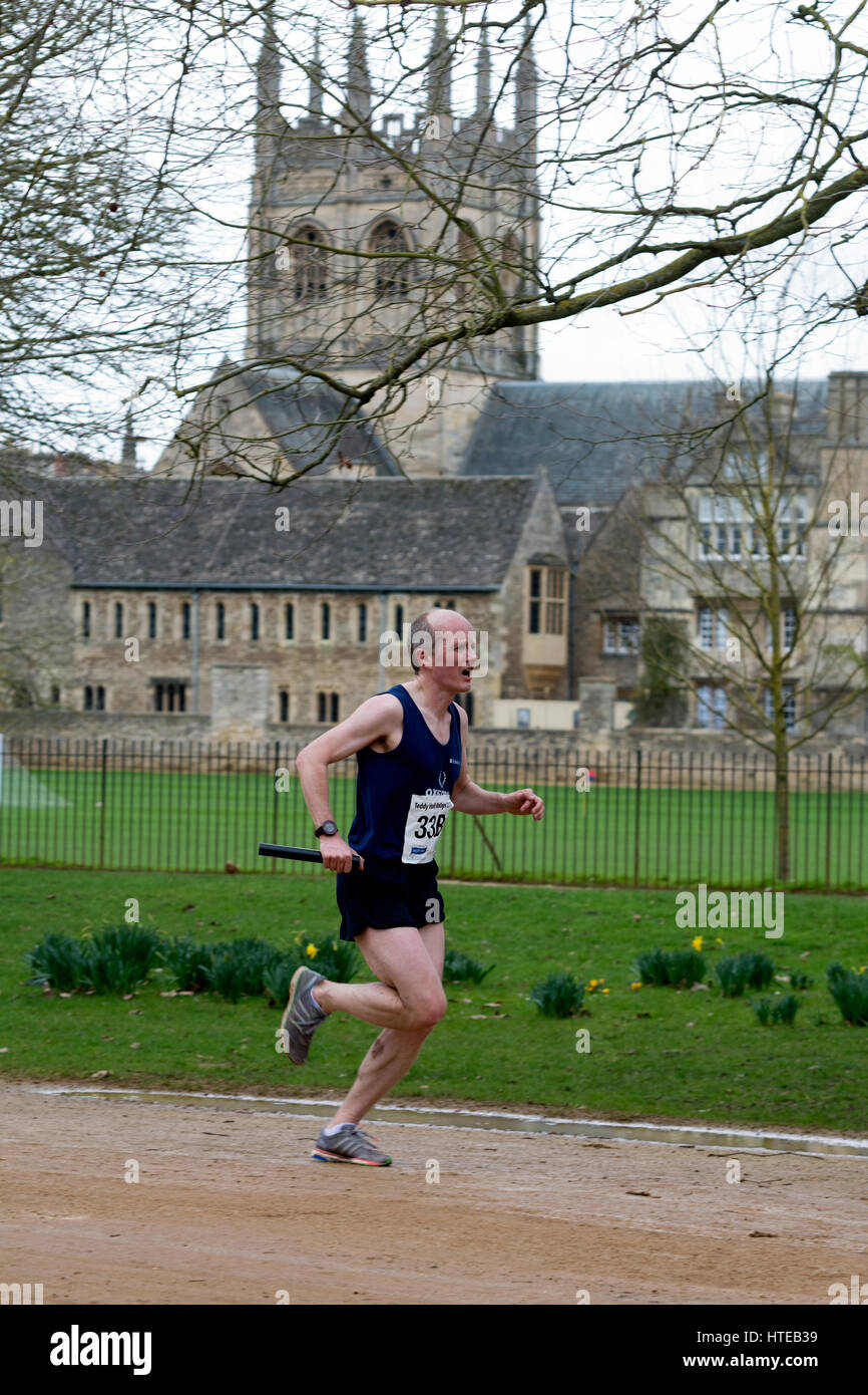 Un runner passando Merton College Chapel in Teddy Hall relè, Oxford, Regno Unito Foto Stock