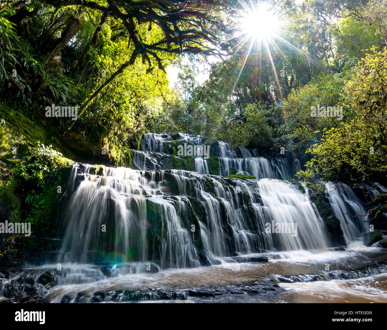 Purakaunui Falls, cascata, Sun Star, il Catlins,, Otago Southland, Nuova Zelanda Foto Stock