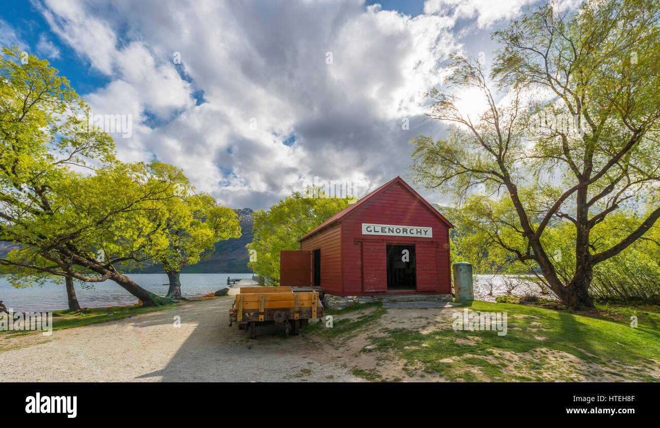 Capanna rosso in piedi accanto al lago Wakatipu, Glenorchy vicino a Queenstown, Alpi del Sud,, Otago Southland, Nuova Zelanda Foto Stock
