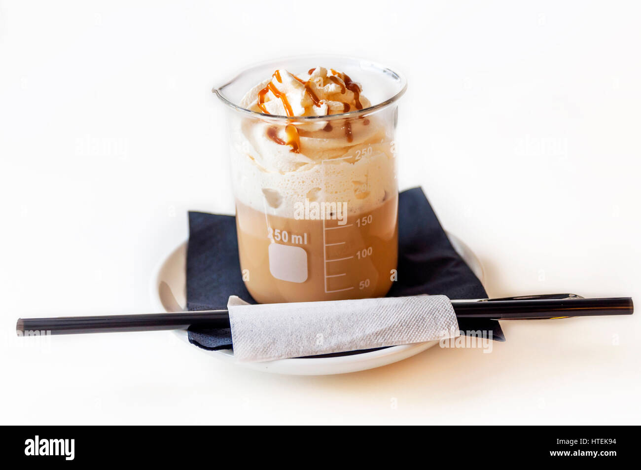 Tazza di un fresco latte al caramello con panna montata su tavola in coffee shop Foto Stock