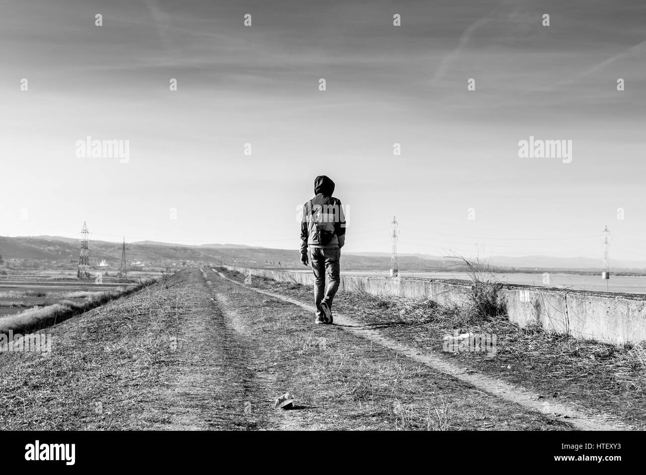 Uomo che cammina sulla strada di un paese Foto Stock