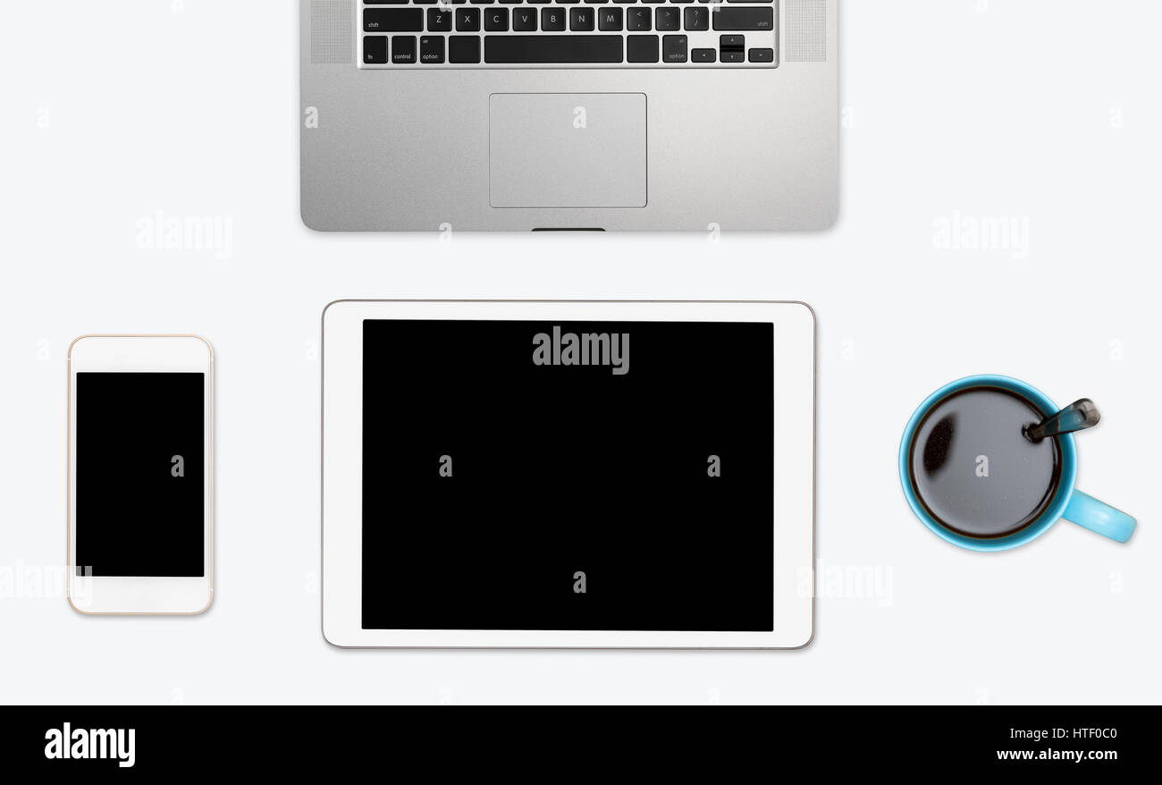 Le moderne apparecchiature di calcolo di smartphone, tablet e laptop con tazza di caffè disposti su semplici desktop bianco con spazio di copia Foto Stock