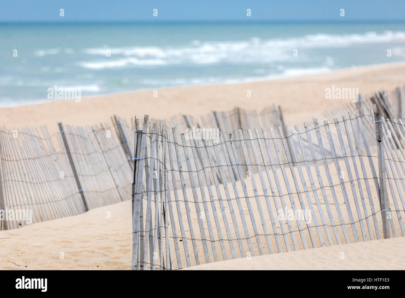 Spiaggia la scherma a una lunga spiaggia dell'isola con l'oceano in arrivo Foto Stock