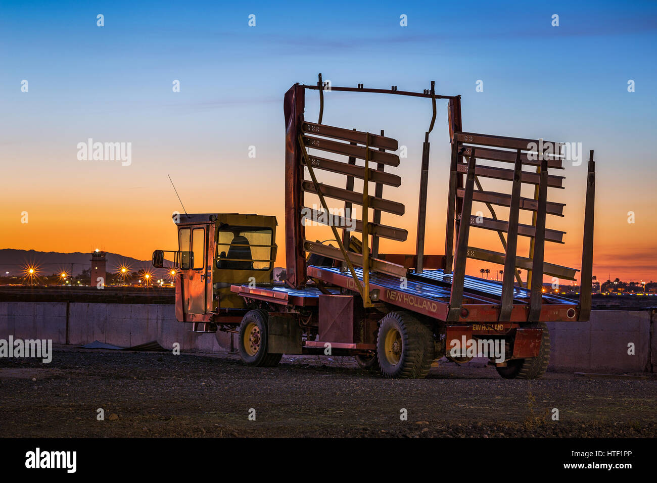 New Holland carrello su una fattoria al tramonto Foto Stock