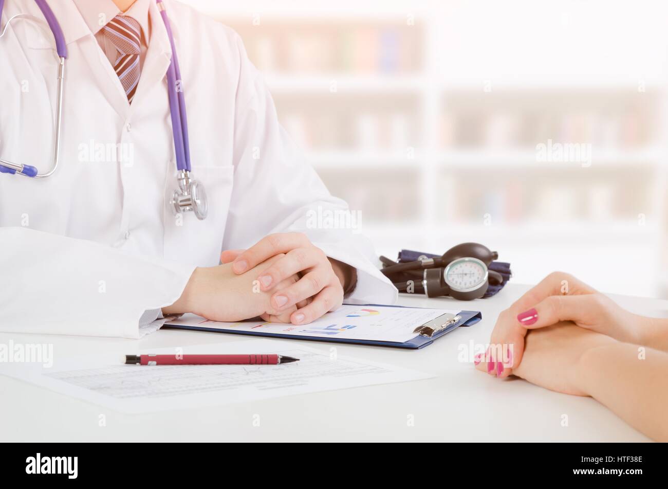 Il medico e il paziente consultazione medica. medico paziente health care office desk stetoscopio concetto medico Foto Stock