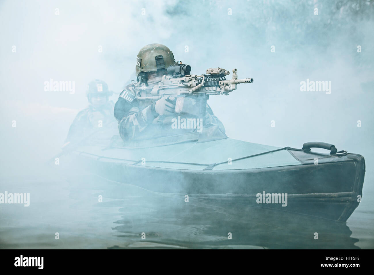 Le forze speciali degli operatori marittimi in camuffamento uniformi esercito di canoa kayak attraverso la nebbia di fiume. Diversivo missione, mitrailleur avanti Foto Stock