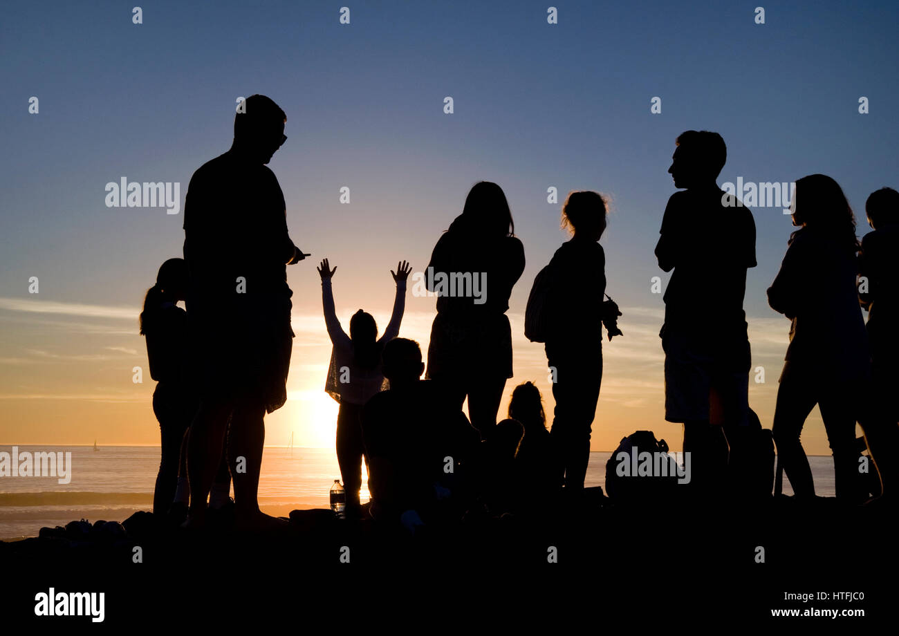 La gente a guardare il tramonto a Venice Beach, CA Foto Stock