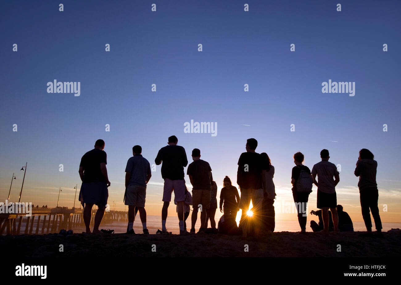 La gente a guardare il tramonto a Venice Beach Foto Stock