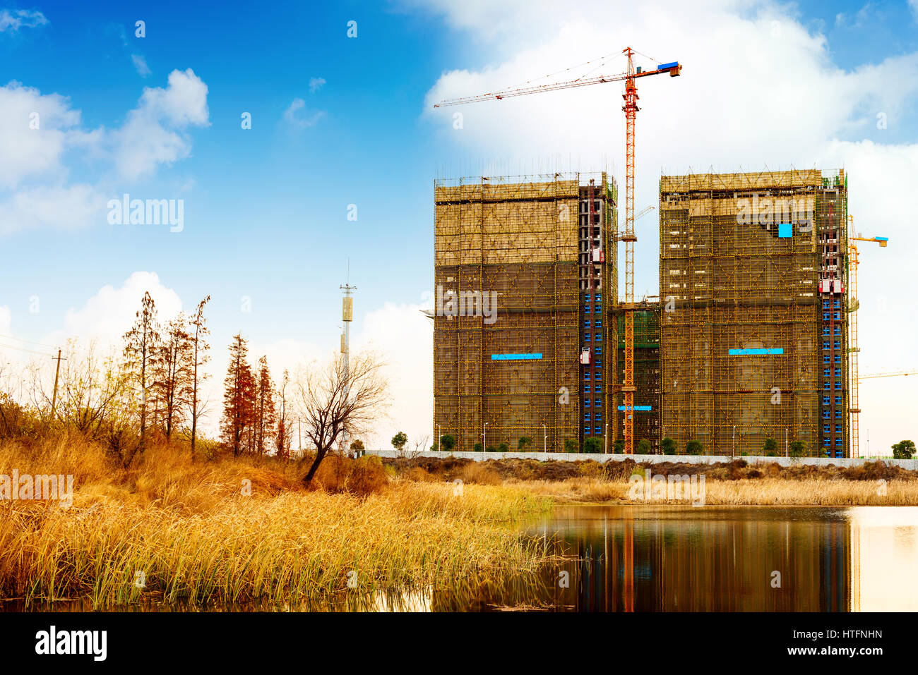 Grande cantiere con gru di lavoro al tramonto per il business Foto Stock