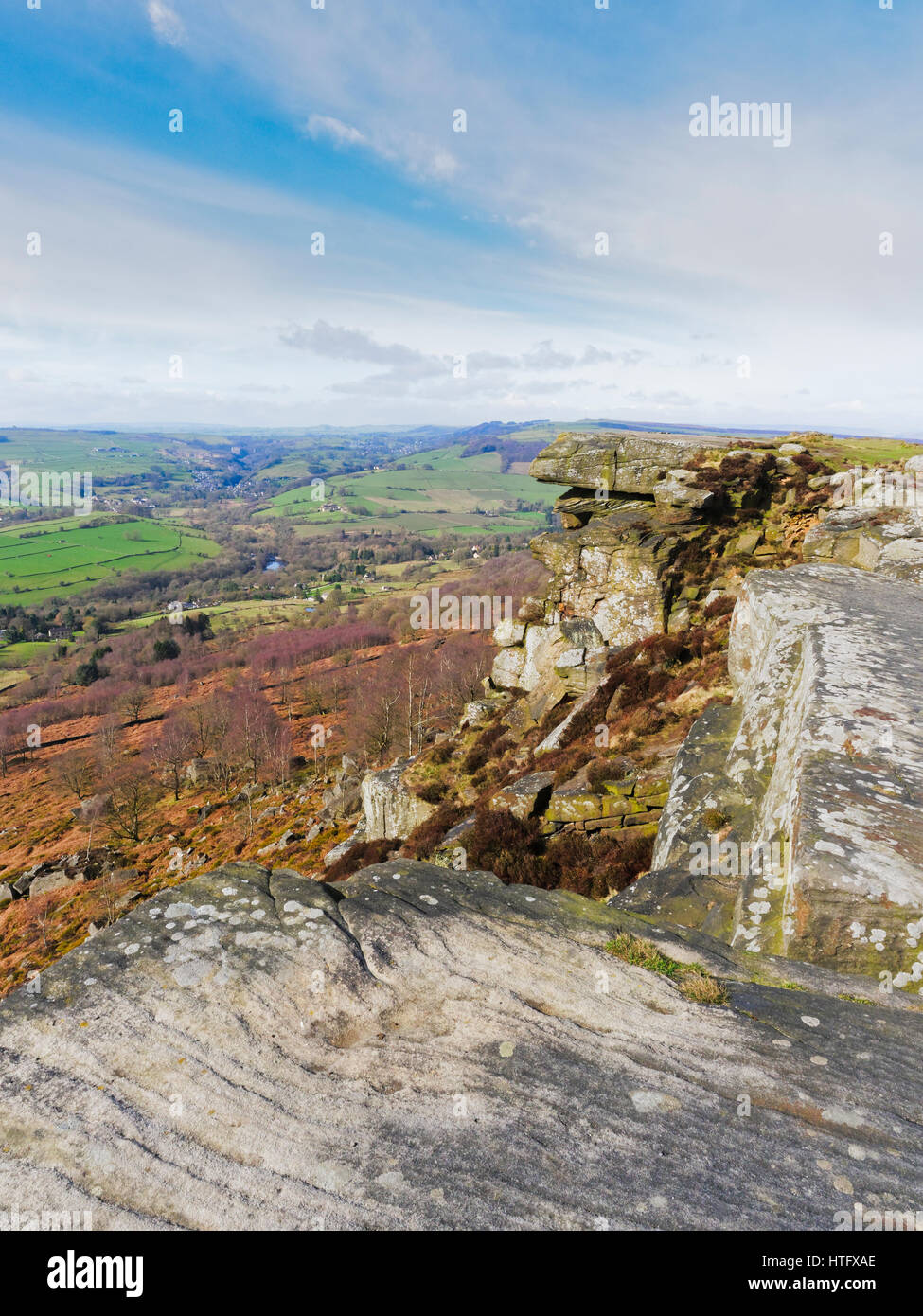 In cima a una collina ripida gritstone scogliere si affacciano sul paesaggio della molla Foto Stock