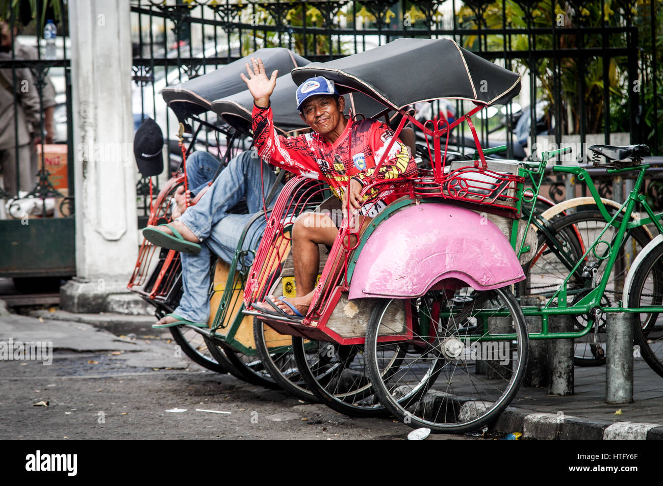 Gentile becak conducente dando un'onda in Yogyakarta - Java, Indonesia Foto Stock