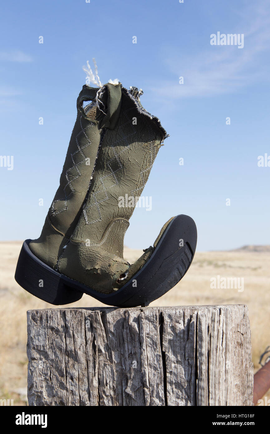 Un cowboy che ha ottenuto il suo denaro vale la pena al di fuori di questo vecchio boot inchiodati in un post, Vananda, MT. Foto Stock