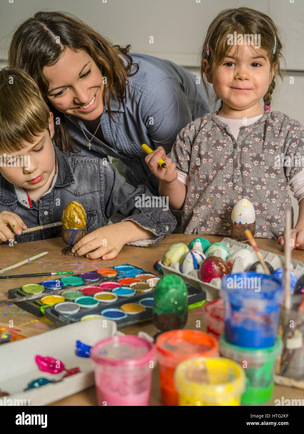 Foto di una madre e i suoi figli la pittura e decorazione di uova sode per la Pasqua. Foto Stock