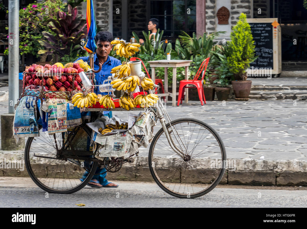 Fornitore di telefonia mobile sul ciclo per la vendita di frutta in Pokhara Nepal Foto Stock