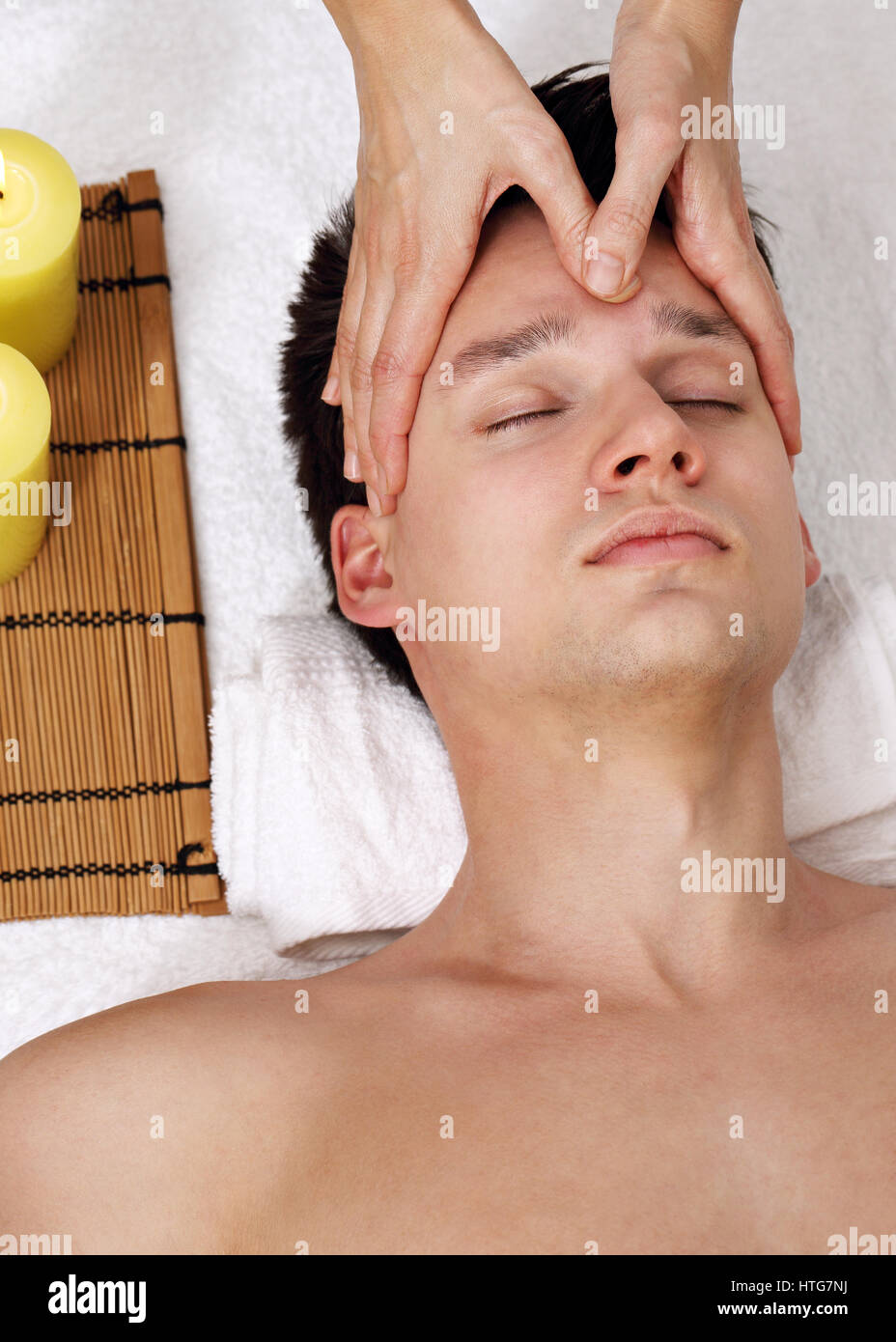Il giovane uomo riceve un massaggio della testa. Foto Stock