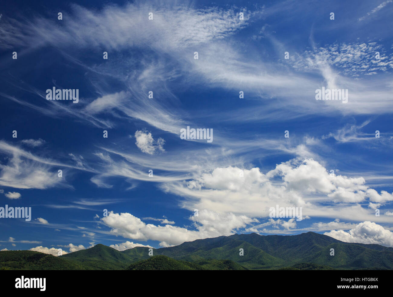 Cirrus e livello inferiore nuvole contro un cielo blu. Foto Stock